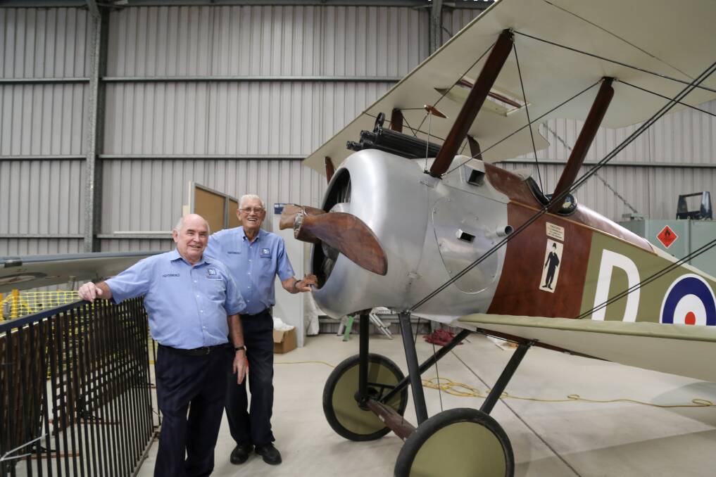 SERVICE: Neville Masters and Les Bowden have been volunteering at Fighter World for 25 years. The pair are pictured with a Sopwith Camel replica on display at the aviation museum.