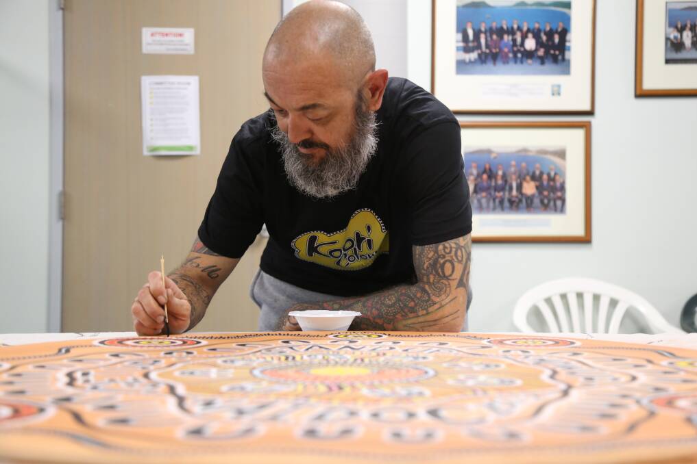 TALENTED: Worimi artist Jason Russell painting at the Port Stephens Council chambers during a NAIDOC Week event on July 5. Mr Russell is exhibiting his work in the Raymond Terrace Art Space throughout July.