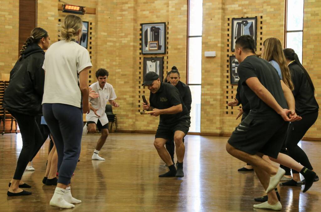 COLLABORATION: David Coleman, centre, leading students and teachers from four Port Stephens and Newcastle schools through a rehearsal of a dance that they will perform before the Knights game during NAIDOC Week. Picture: Ellie-Marie Watts