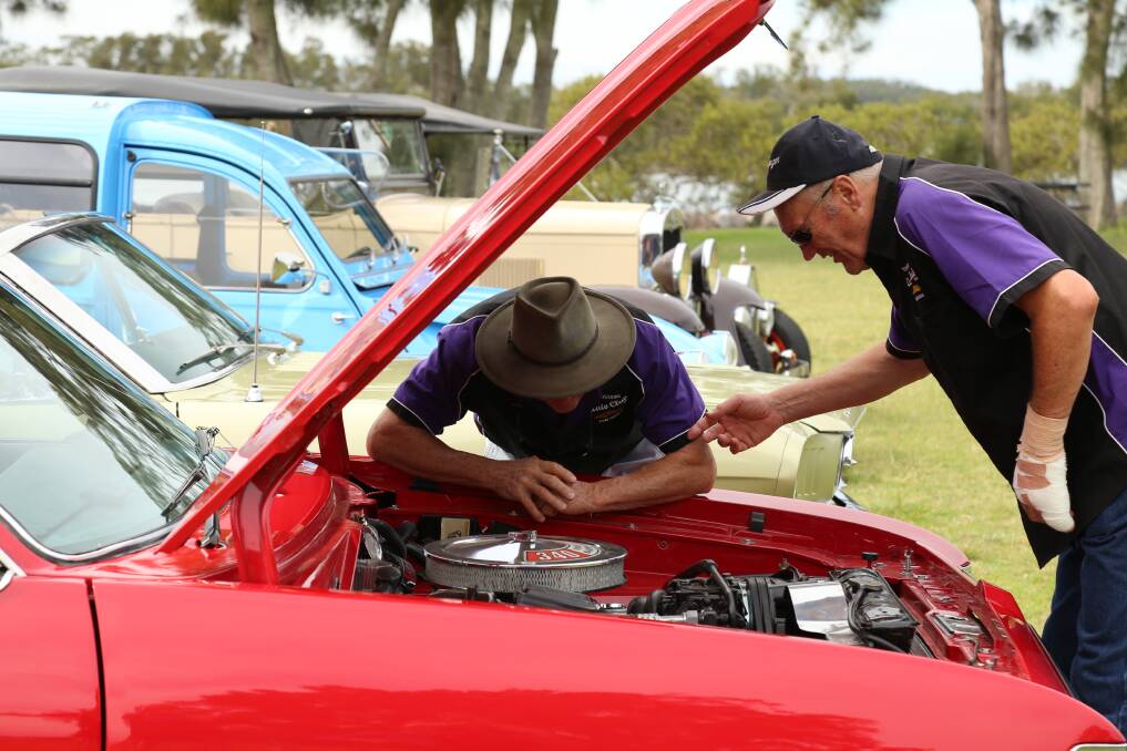Phillip Robinson and Geoff Nutt looking under the hood of Mr Nutt's 1976 Chrysler Charger.