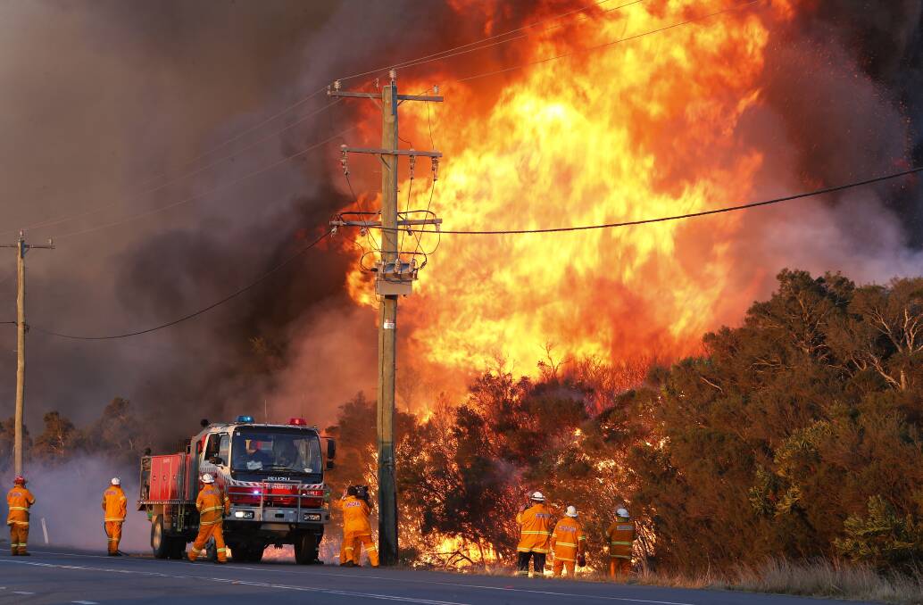DANGEROUS: Fire crews at Salt Ash on Sunday before an emergency warning was sent to residents in the area. Picture: AAP Image/Darren Pateman