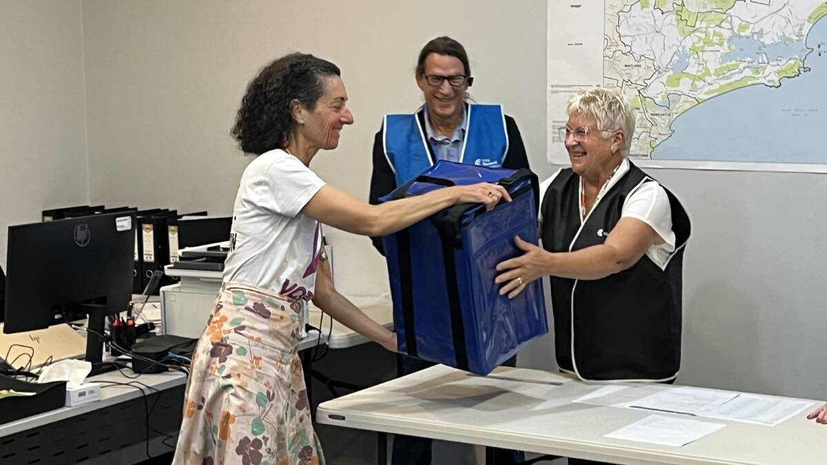 Angela Ketas at the Port Stephens ballot draw in Raymond Terrace on March 9. Ms Ketas is shaking the ballot box with the names of the Port Stephens candidates inside ahead of the draw to determine the order they will appear on ballot papers. Picture by Ellie-Marie Watts