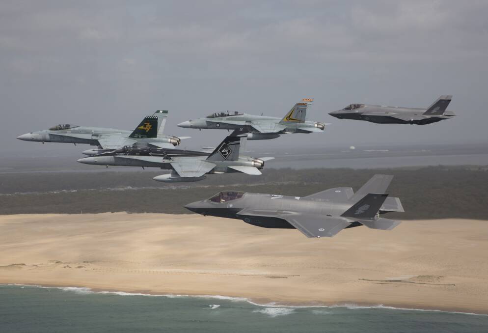 Royal Australian Air Force F/A-18 Hornets fly in formation with a pair of F-35A Joint Strike Fighters over Stockton Beach. Picture: CPL David Gibbs