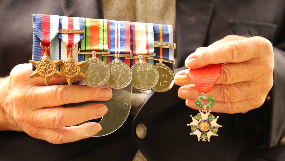 North Arm Cove WWII veteran Jim Clayton hold his medals including, right, the French Legion of Honour medal, awarded in 2015. Picture: Ellie-Marie Watts