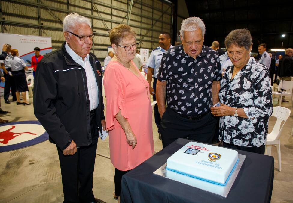 Worimi elders Uncle Neville and Lorraine Lilley along with Uncle John and Sandra Ridgeway read the inscription on the cake made to celebrate the 80th anniversary of RAAF Base Williamtown and the 30th anniversary of Fighter World. Picture: CPL Craig Barrett