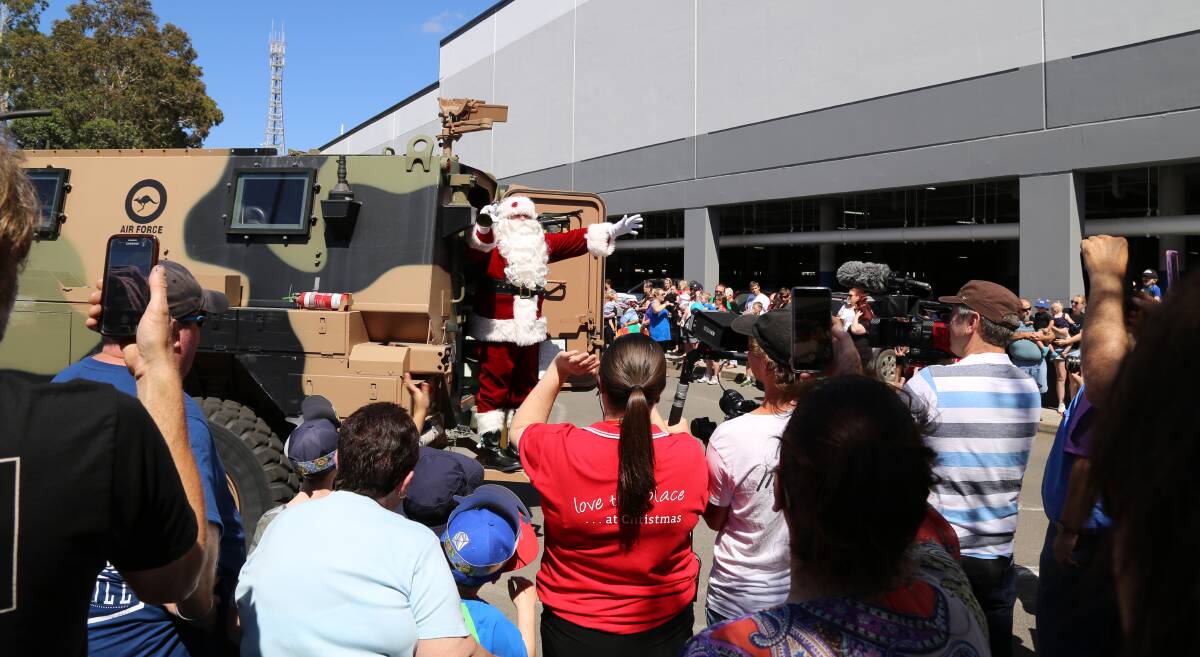 Joined by a parade of friends, Santa arrived in Raymond Terrace last year in a Williamtown RAAF Base Bushmaster troop carrier. Pictures: Ellie-Marie Watts