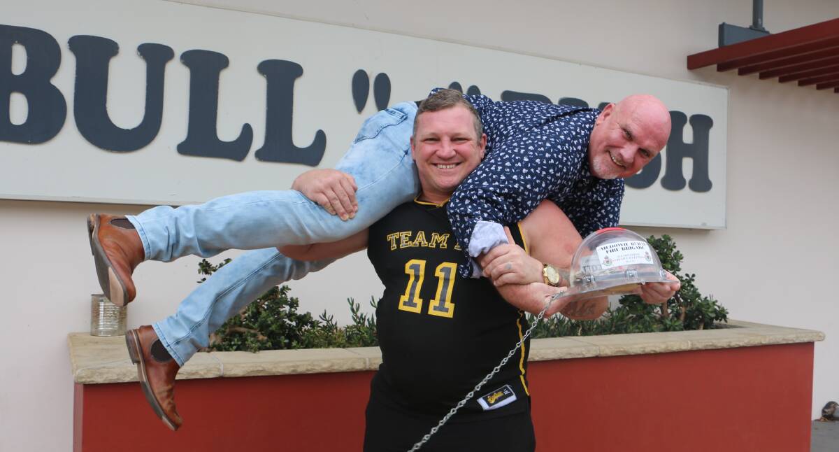 FOR THE FIRIES: Medowie strongman Benny Chessum lifts Chris Doohan in a fireman's carry for charity. Picture: Charlie Elias