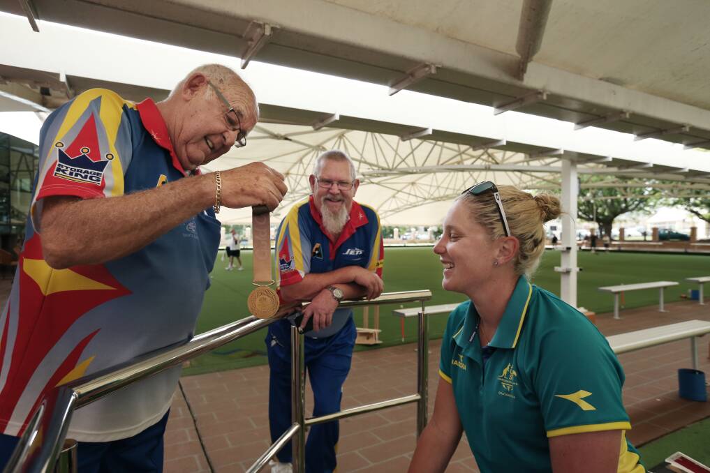 Natasha Van Eldik showing her two gold medals to Raymond Terrace Bowling Club director Merv Aunger and club member Rod Partridge after the 2018 Gold Coast Games. Picture: Simone de Peak