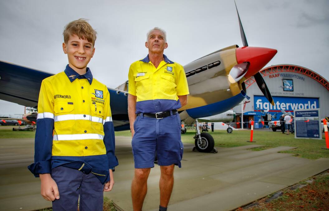 Fighterworld volunteer Bob Mason and his Grandson Ryder with a P-40E Kittyhawk that completed a fly past in celebration of the 80th anniversary of RAAF Base Williamtown and the 30th anniversary of Fighter World. Picture: CPL Craig Barrett