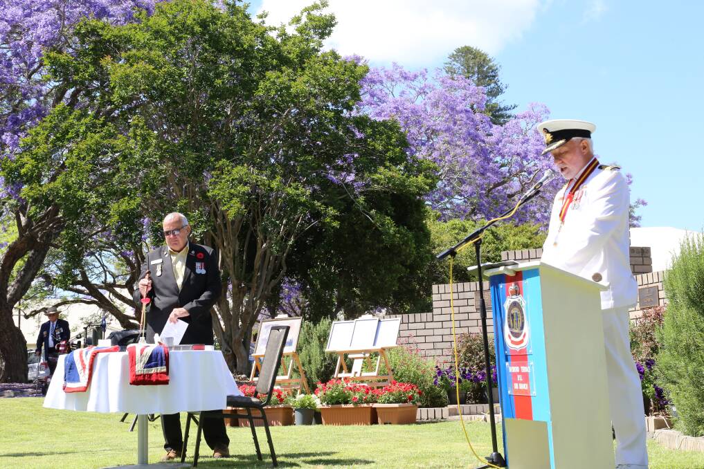 Raymond Terrace RSL Sub-Branch president Vic Jones RAR, right, reciting the Table of Remembrance poem written by O.J Rushton while a member of the sub-branch points to the item mentioned.