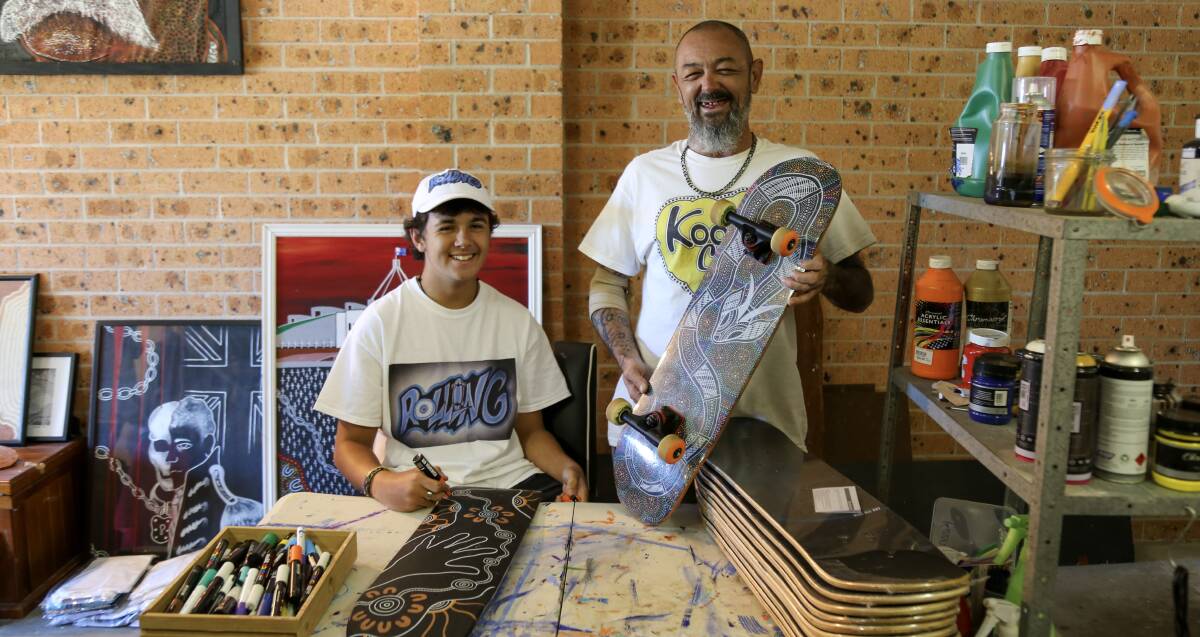 SIGN UP: Rohan Russell, 17, with father and Worimi artist Jason Russell in his Tanilba Bay studio.
