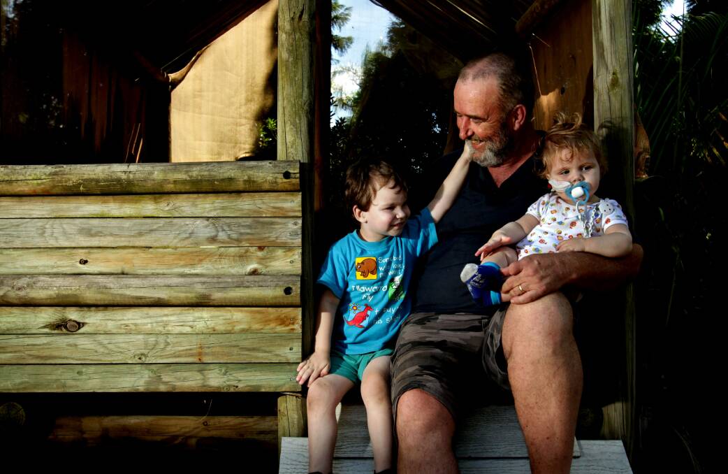 Jordan Weir, 3, and Logan Weir, 11 months, at home in the backyard at Raymond Terrace with their grandfather Chris Walker in 2013. Picture: Simone De Peak