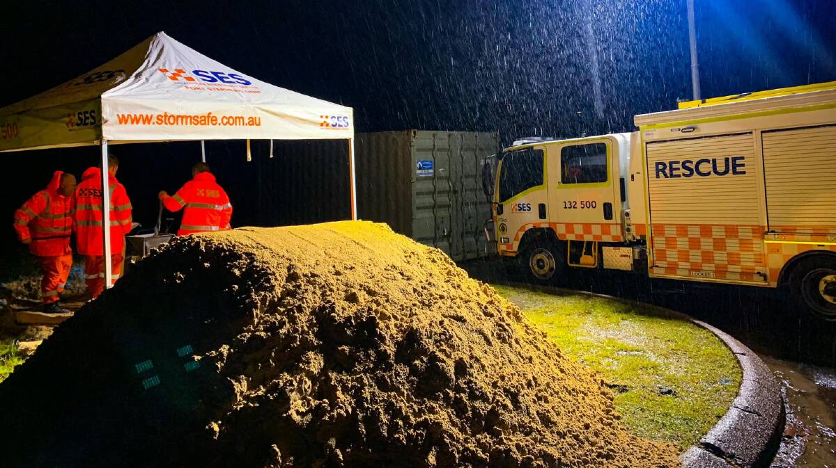 Port Stephens SES Unit members creating sandbags on Sunday night. More than 300 were filled.