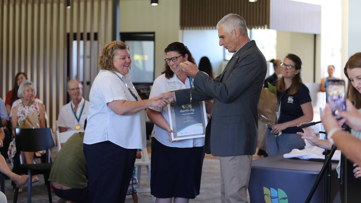 SERVICE REWARDED: Councillor John Nell presenting Medowie Girl Guides district leaders Rachael Bass and Elizabeth Keeley a Port Stephens Medal.