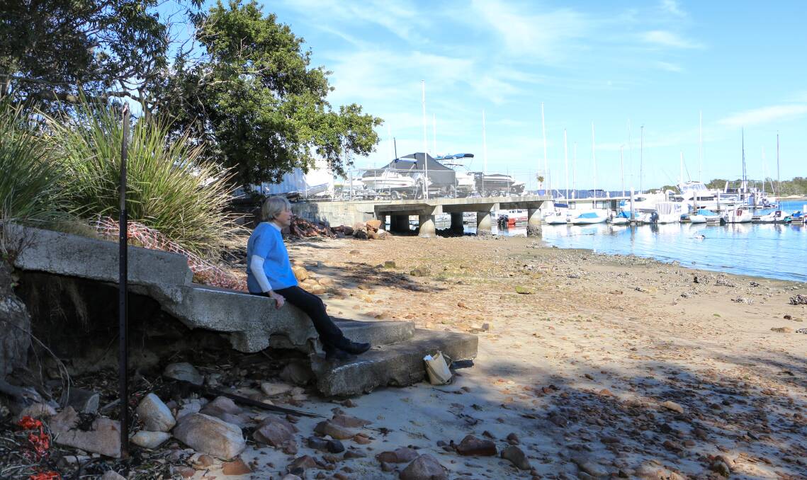 EROSION: Soldiers Point resident advocate Jean Armstrong points takes in the view from the broken steps caused by erosion near the Soldiers Point marina.
