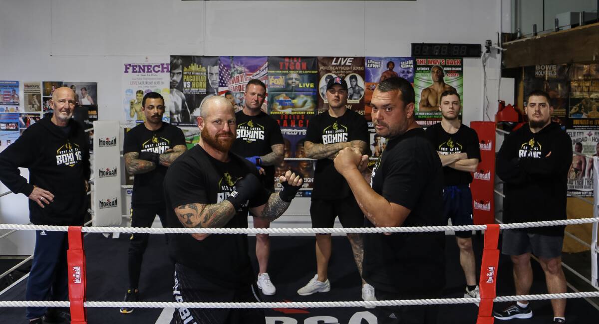 NEXT LEVEL: Adam Dawkins and Ben Whaler square off, watched by members of Next Level Boxing in Salamander Bay, operated by Aaron Cocco (third from right). 
