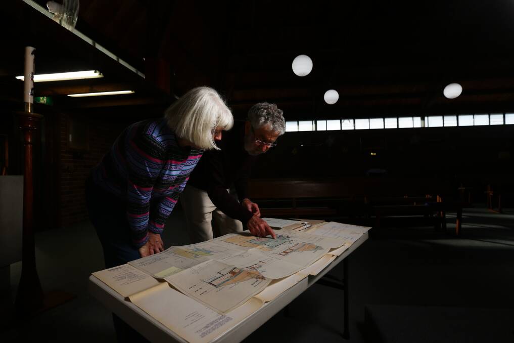Brian Suters looks at the church plans with parishioner Linda Carter. Picture: Jonathan Carroll