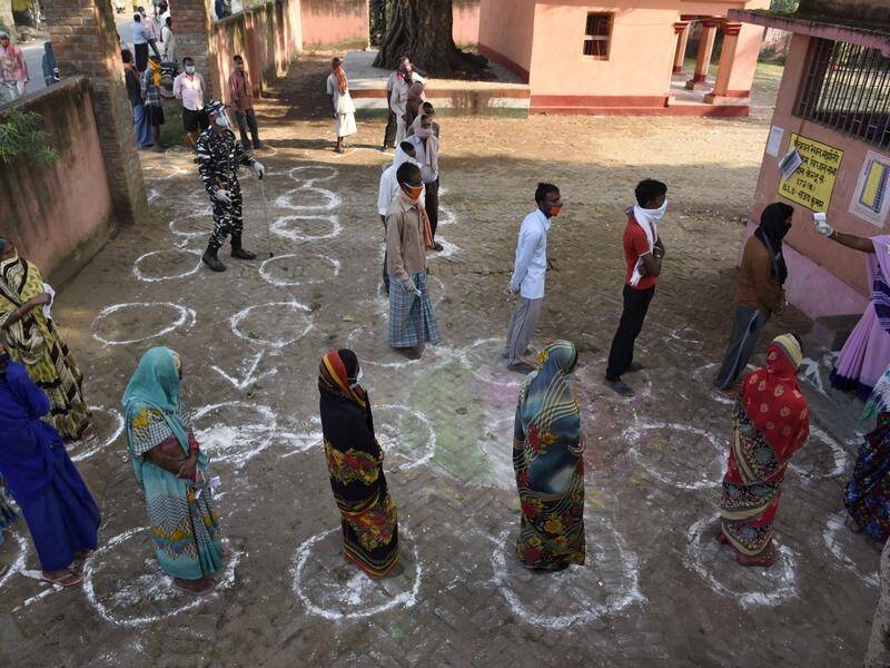 Voters keep social distance before voting in state elections in the eastern Indian state of Bihar.