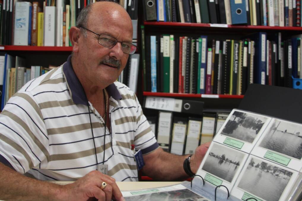 UNDER WATER: Raymond Terrace Historical Society president Ken Barlow looking back through the history books to the 1955 flood. Picture: Ellie-Marie Watts