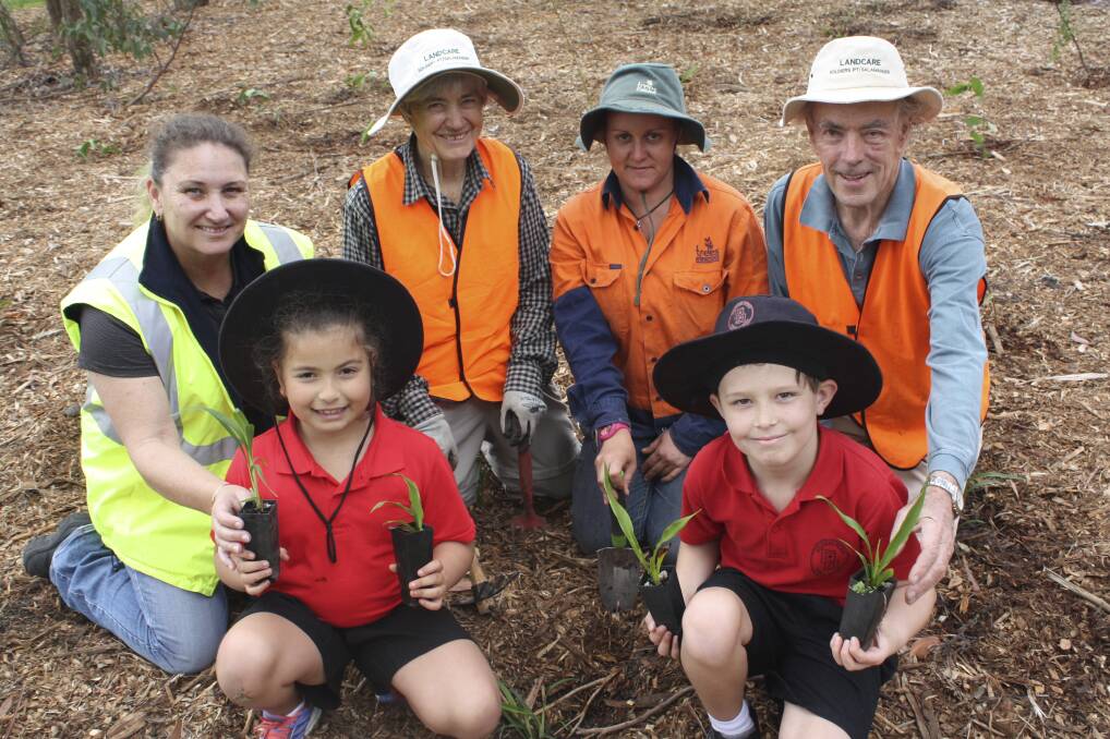 HELPING OUT: Students Judy Hamzeh, 8, and Archie Stringer, 8, with Charly Wellard (PSC), Margaret Lamond (Landcare), Joanna Rain (Trees In Newcastle) and Simon Brooke (Landcare). Picture: Charles Elias