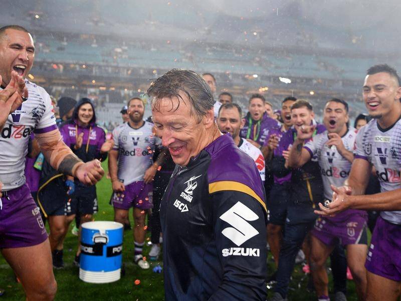 Storm coach Craig Bellamy celebrates with his team after their NRL grand final triumph.