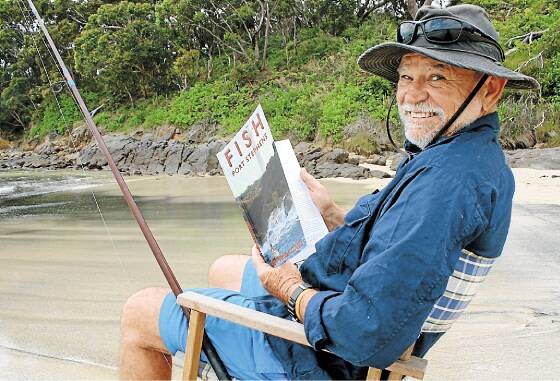 UPDATE: John "Stinker" Clarke at Fingal Beach with his new book. Picture: Stephen Wark