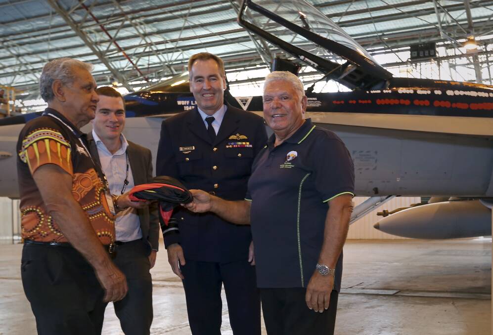CEREMONY: Air Marshal Geoff Brown presents Worimi elders Neville Lilley and John Ridgeway with the Aboriginal flag used in the F/A-18A Worimi Hornet unveiling. Picture: CPL Ben Dempster