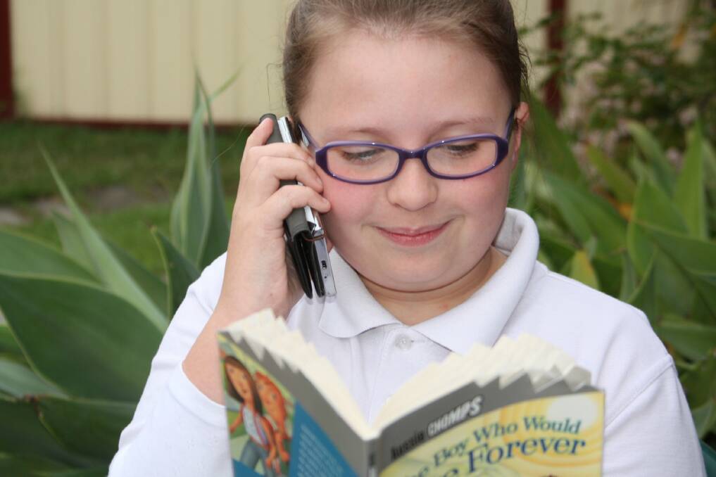 TEXT TALK: Claire Harris, 10, at her home in Raymond Terrace, is part of a new phone reading program. Picture: Stephen Wark