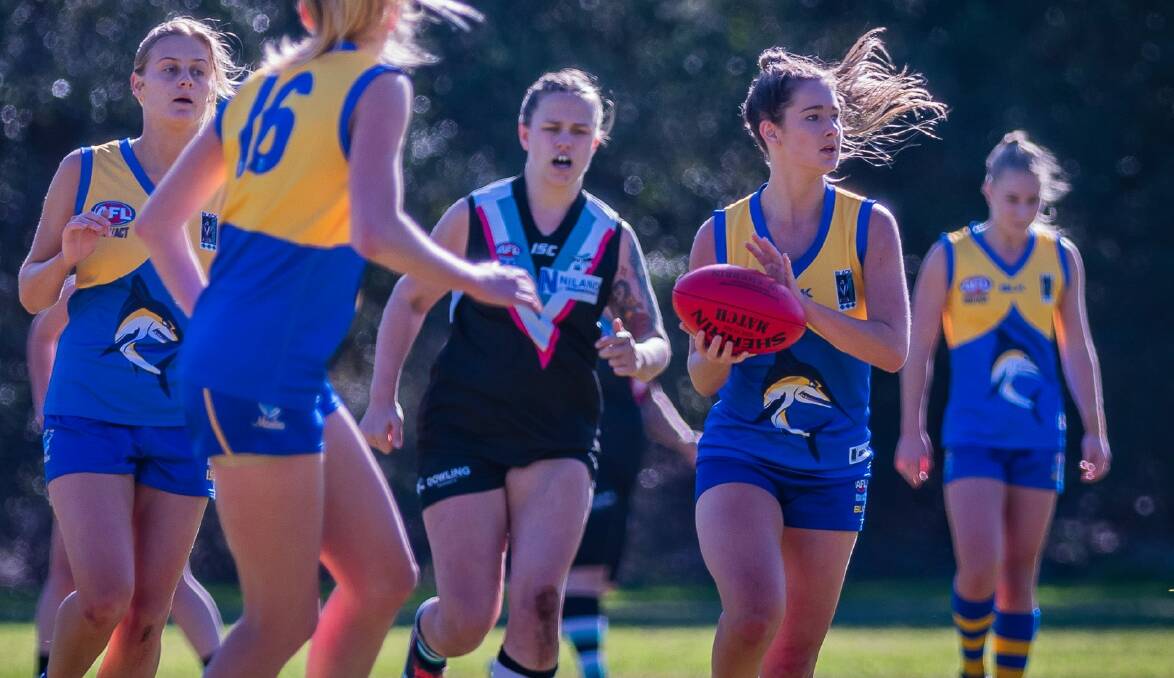 CATALYST: Kaitlyn Douglass (holding the footy) was key for Nelson Bay as they surged to a 199-point victory over their neighbouring rivals Port Stephens. Picture: Ken Hogan