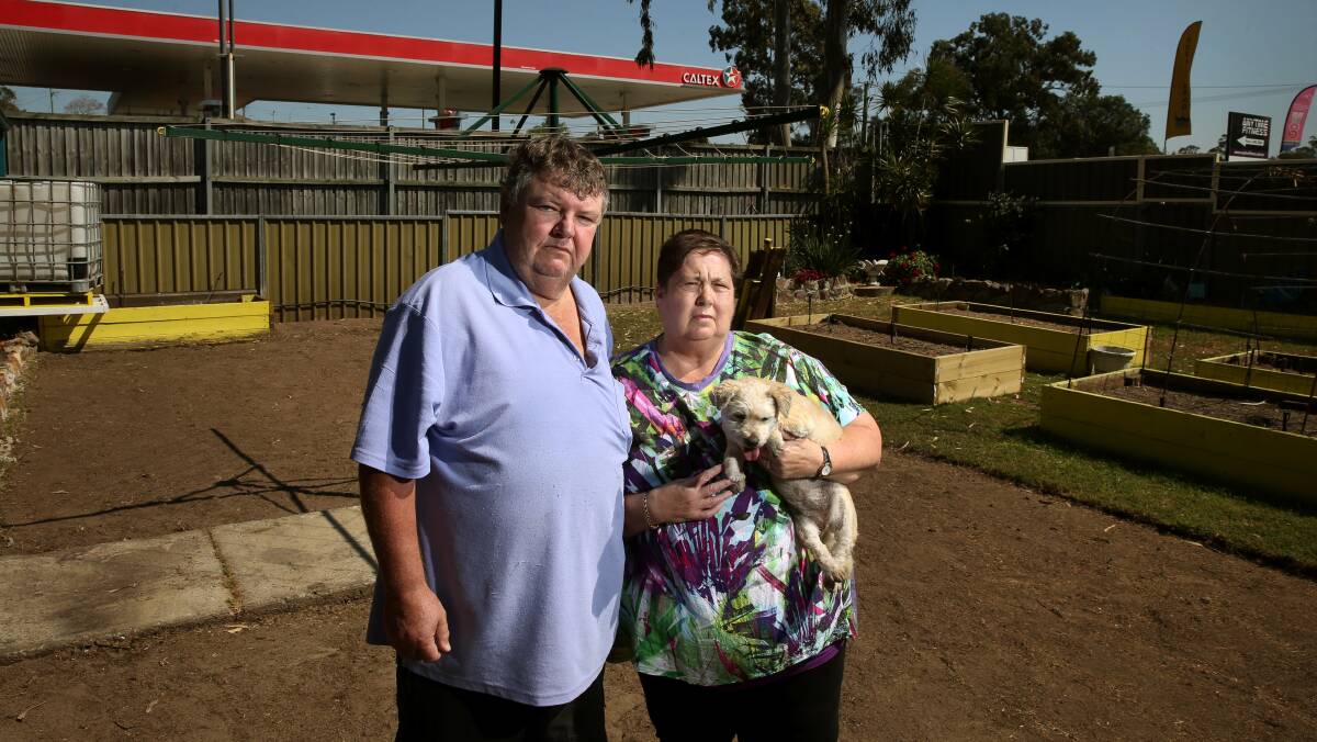 Damaged: Craig and Margaret Kirby in their yard near to the Richardson Road service station. Picture: Marina Neil