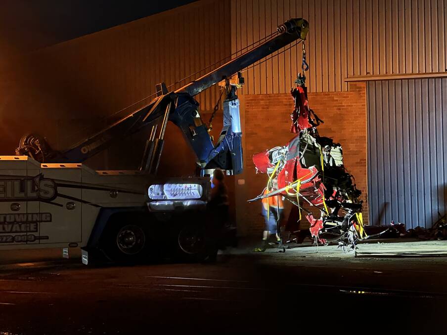 The wreckage of the helicopter is taken to a storage facility at Wickham on Saturday night. Picture by Wez