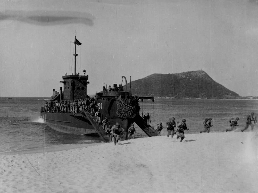US Soldiers charge on to Shoal Bay Beach from a large infantry landing craft as part of a training exercise.